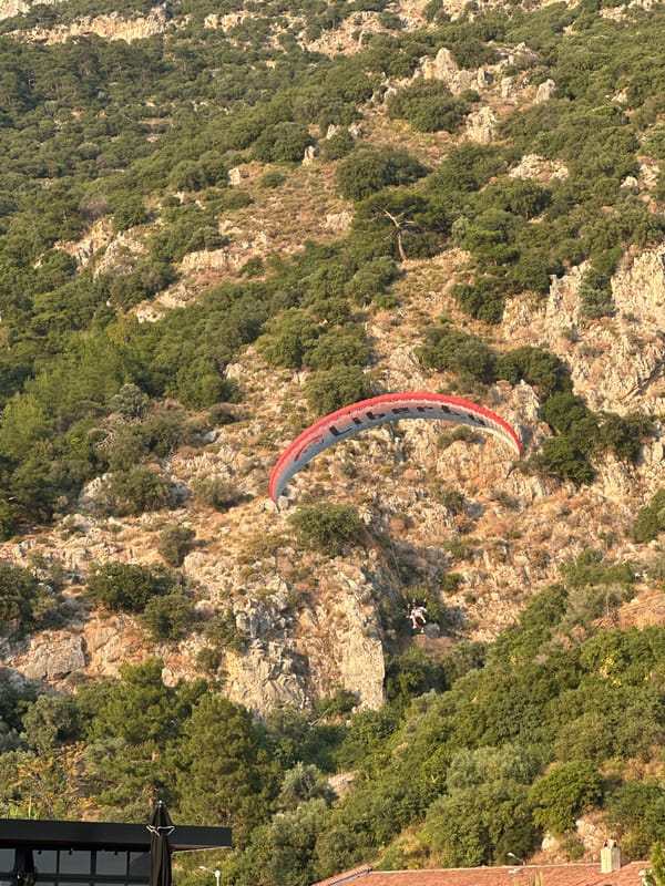 Paragliders descend over Fethiye beaches during golden hour activities