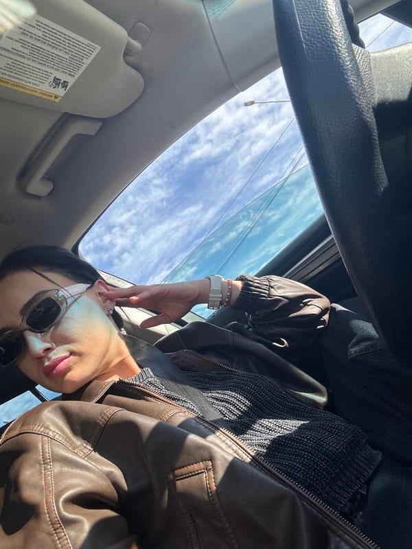 Woman in leather jacket sits in car in Tbilisi