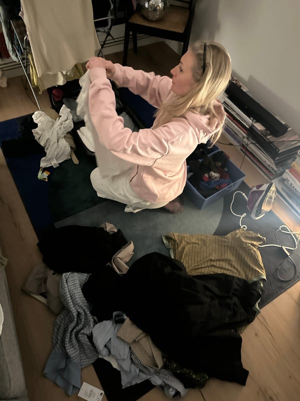 Woman folding laundry at home in London evening
