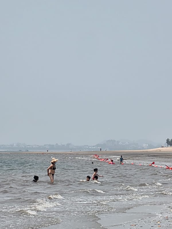 Man wades, gestures in early morning waters at Vietnam beach
