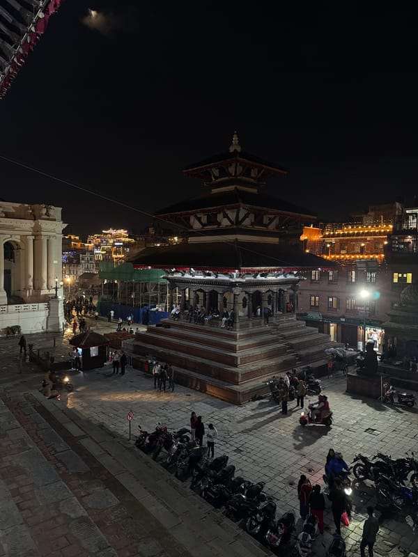 Nighttime activity documented around illuminated pagoda in Kathmandu square