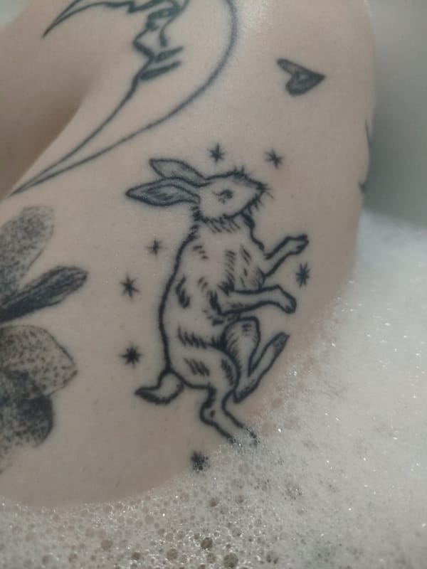 Person with multiple tattoos takes bubble bath