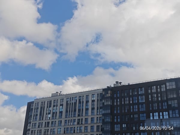 Modern apartment building with contrasting facades observed under cloudy skies