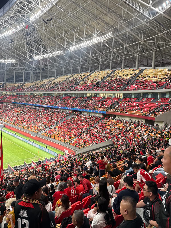 Stadium packed with red-black wearing fans in Longxing
