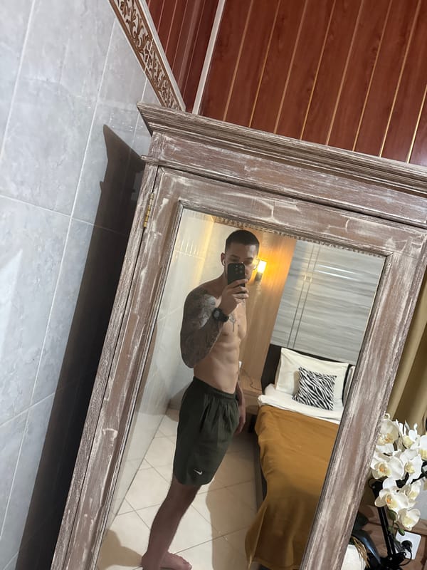 Man Takes Morning Selfie in Bedroom Mirror in Munggu