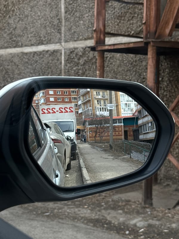 Morning street scene reflected in car mirror in Irkutsk
