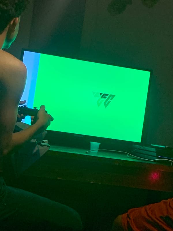 Person gaming with controller, green logo screen visible