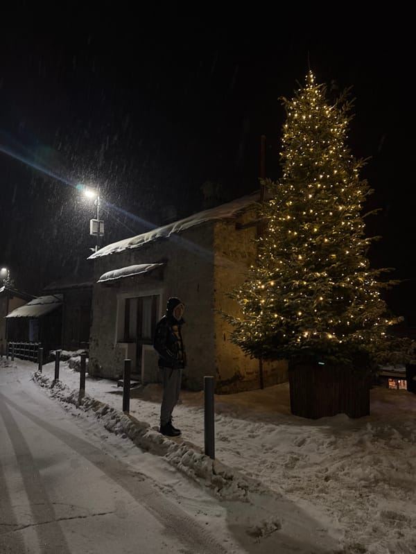 Person moves through snow-covered Italian valley amid Christmas decorations