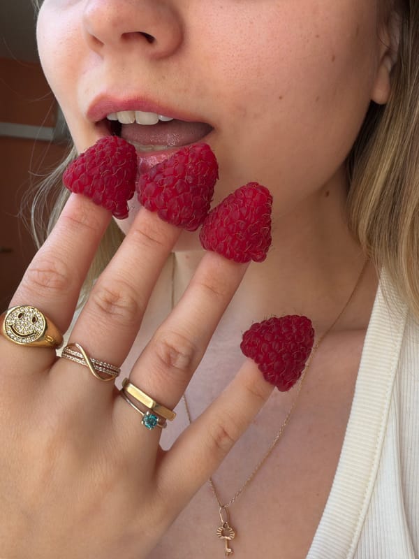 Woman poses with raspberries on fingers in Tel Aviv
