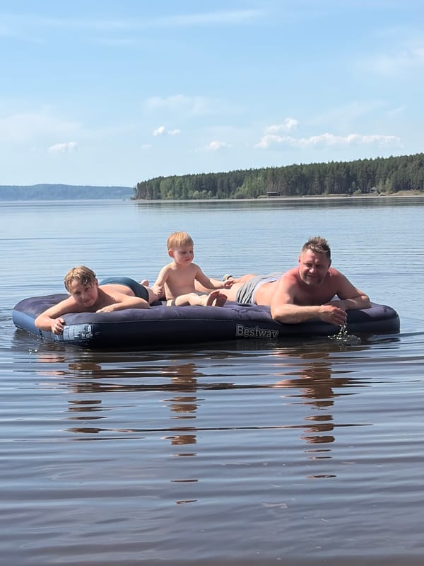 Family group rafting on lake near Vekoshinka, Russia
