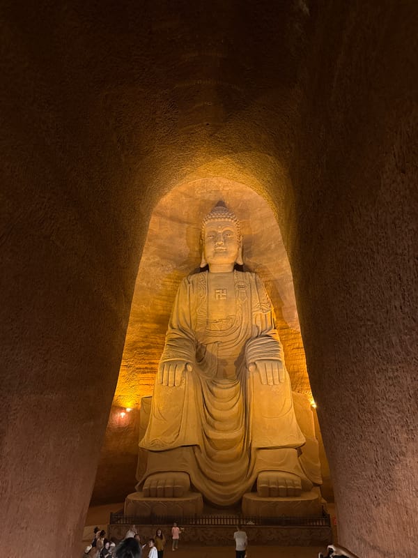 Reclining Buddha statue observed in illuminated cave setting