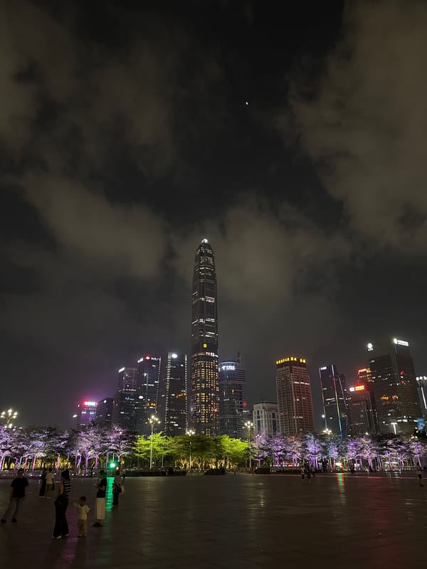 Crowd gathers at illuminated Futian District plaza under crescent moon