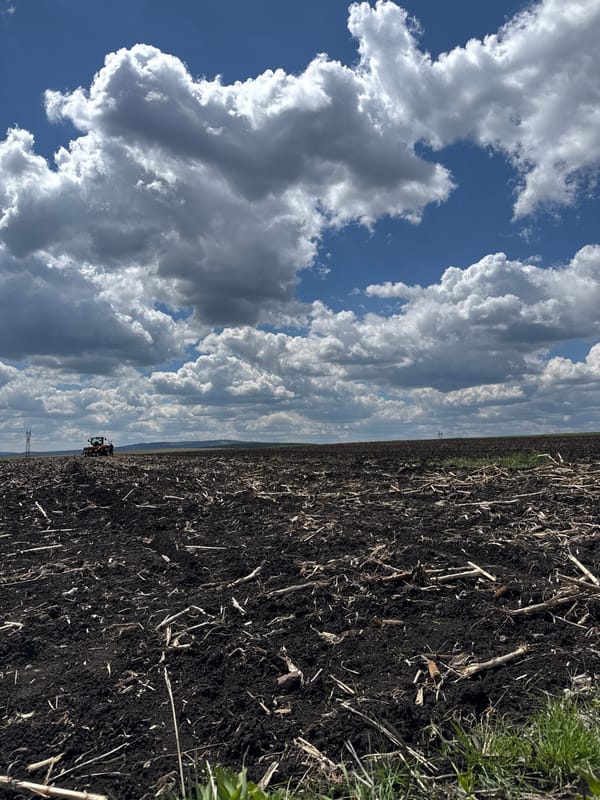 Crane truck lifts white bag in Bulgarian field