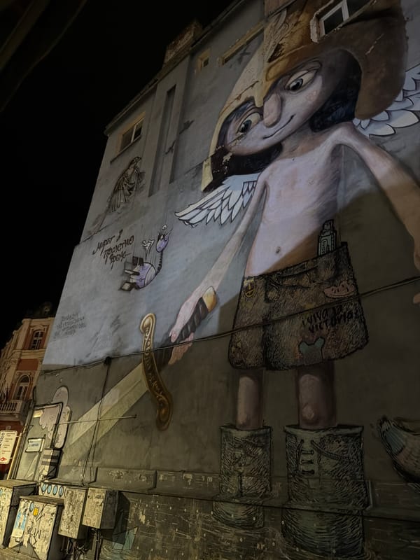 Winged warrior mural on a Pleven building wall at night
