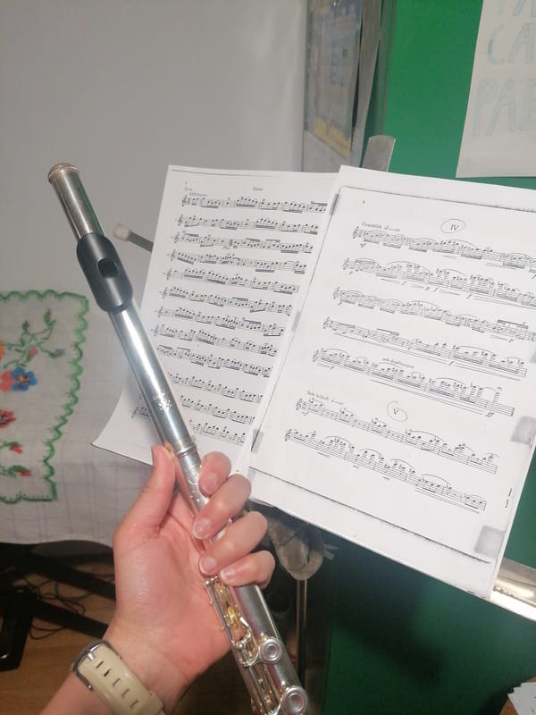 Musician photographed with flute and sheet music during practice