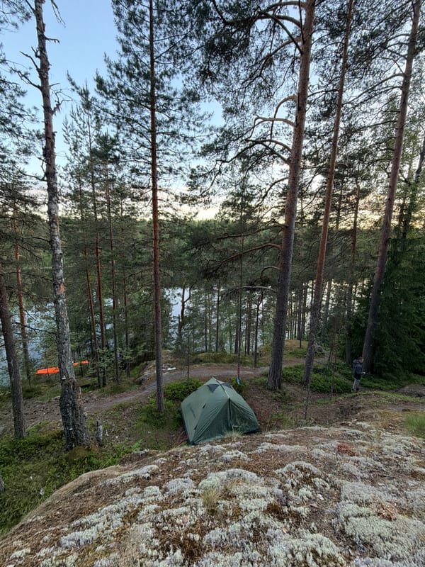Forest camping setup near Russian lakes with tent and stove