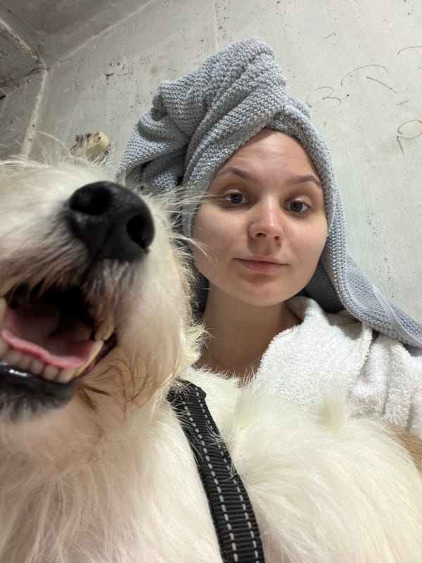 Woman takes selfie with white dog after shower