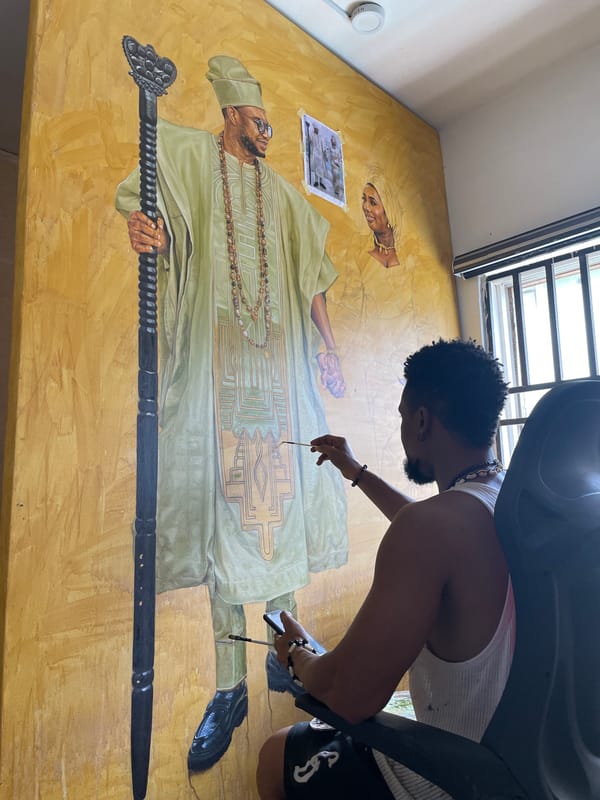Artist paints large traditional figure mural on yellow wall