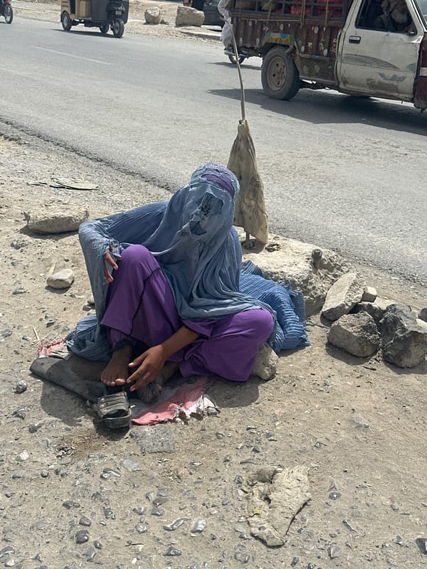 Person in burqa sits roadside in Quetta, Pakistan