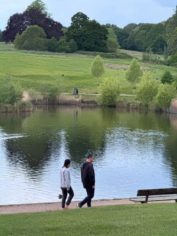 Two people stand by London waterway during evening hours