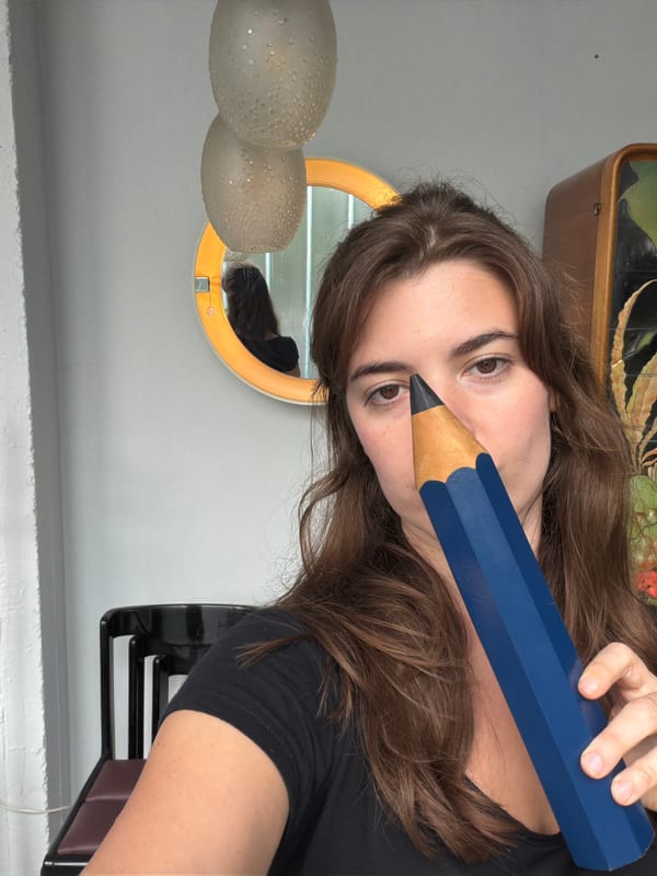 Person poses with oversized blue pencil in Buenos Aires