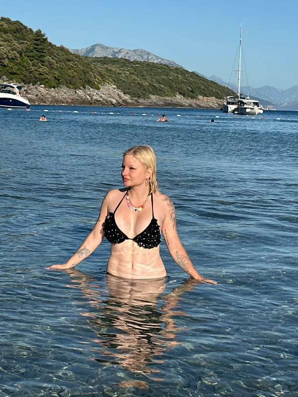 Beachgoers enjoy sunny afternoon in Montenegro's clear coastal waters