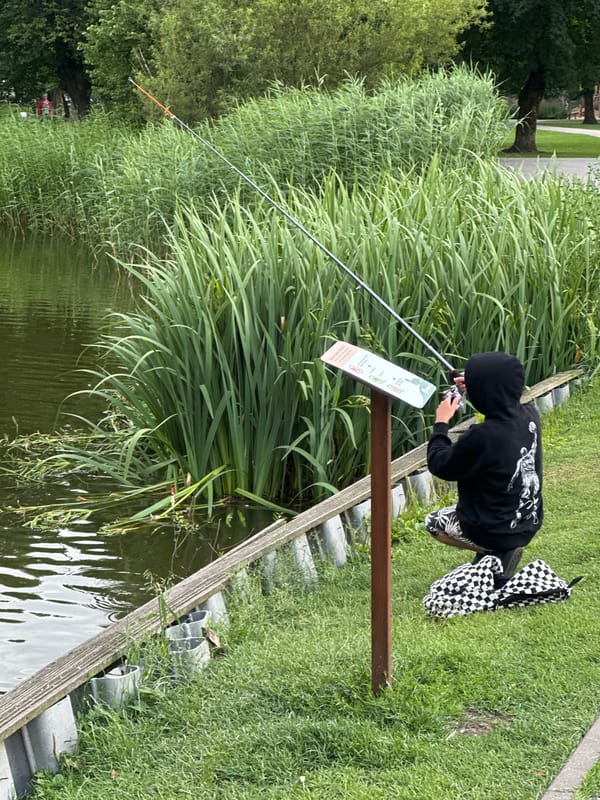 Fishing and ducks along a calm Riga waterway