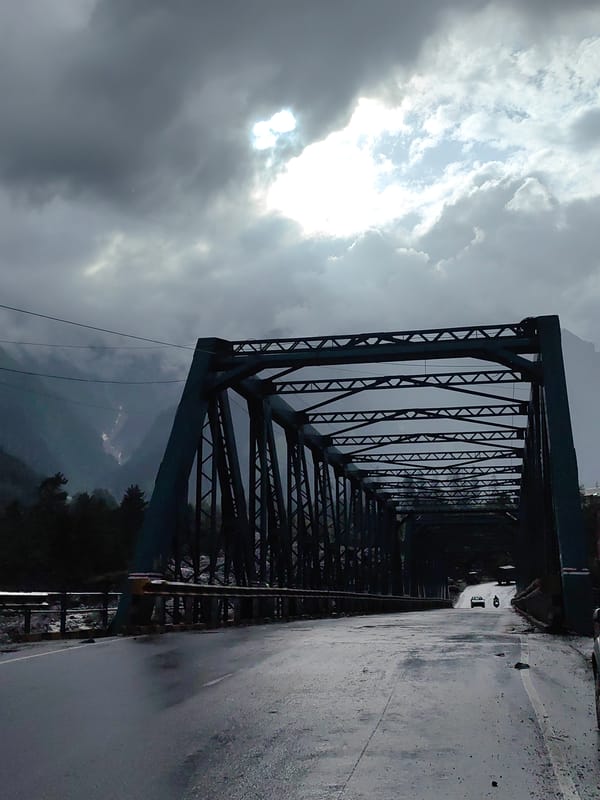 Wet bridge crossing and misty mountain views in Palchan