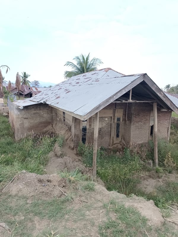 Damaged village structures and disturbed land in rural Aceh