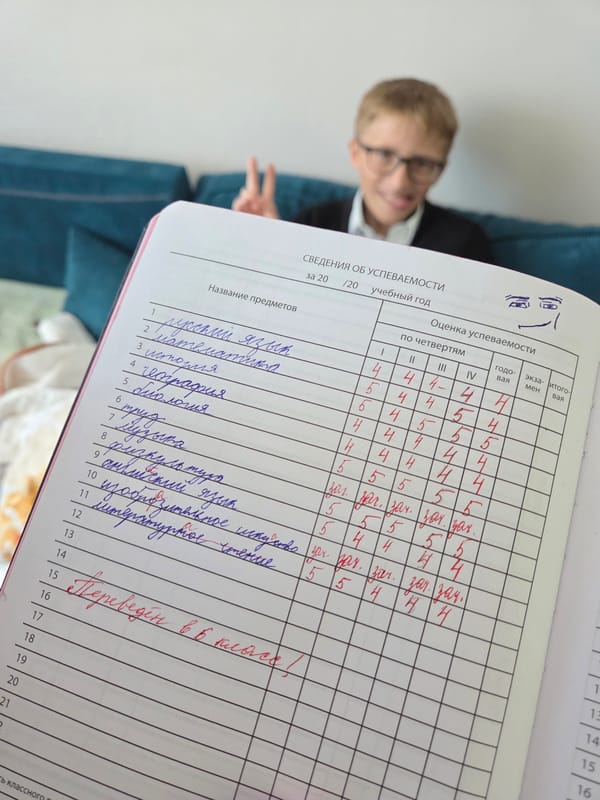 Student displays school records while making peace sign in Birobidzhan