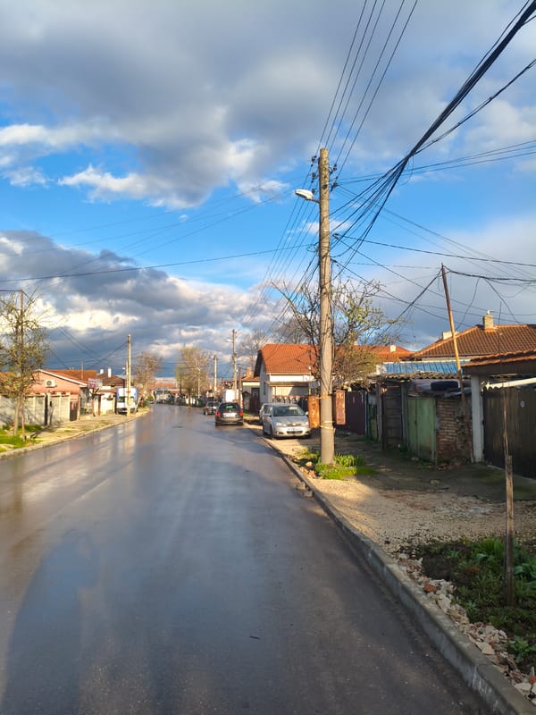 Rain-soaked street reflects cloudy sky in Dobrich, Bulgaria