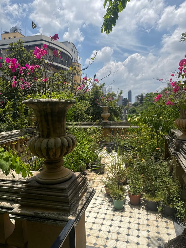 Ornate Bangkok venue with gardens, shrine, and stone walkways