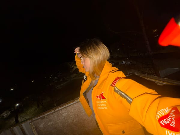 Woman in patched yellow jacket photographed during nighttime selfie session