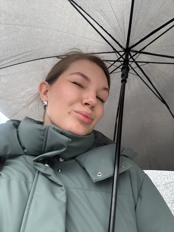 Woman shelters under umbrella during rainy morning in Belgrade