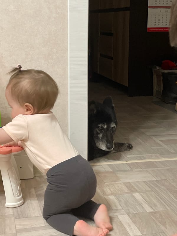 Baby girl plays with backpack on floor in Chaikovsky