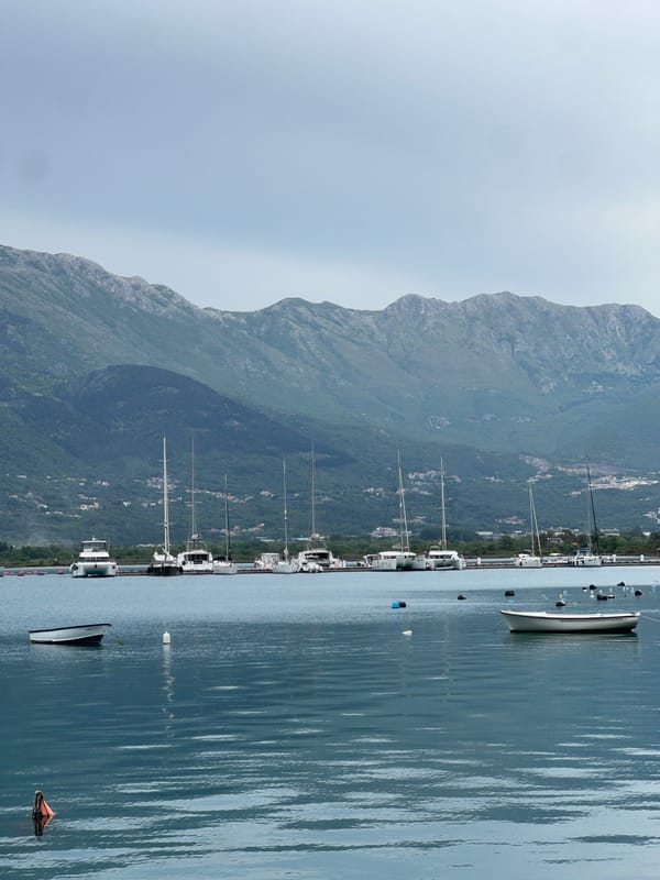 Boats moored in quiet Đuraševići harbor, Montenegro