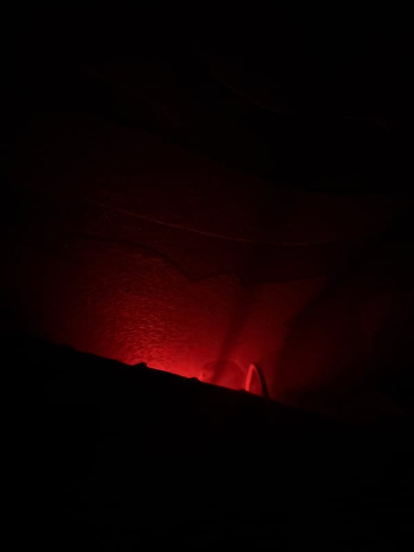 Hand captured in mysterious red-lit dark environment