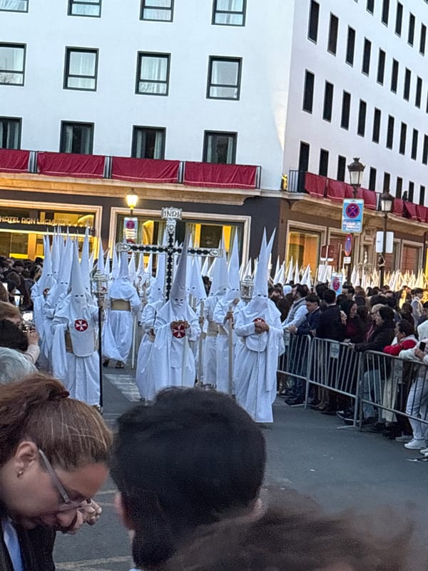 Religious procession with robed participants observed in Seville