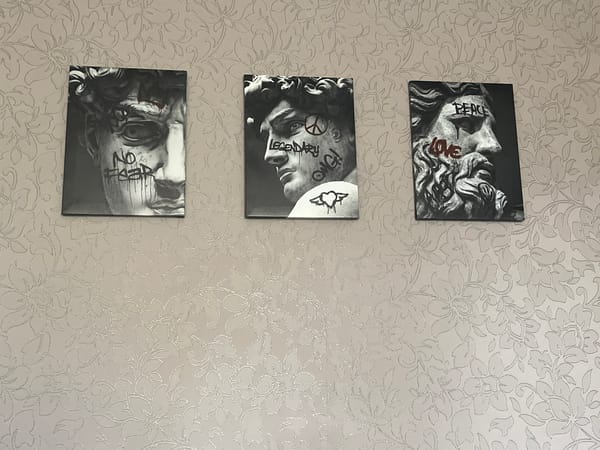 Interior artwork display documented in floral-wallpapered room