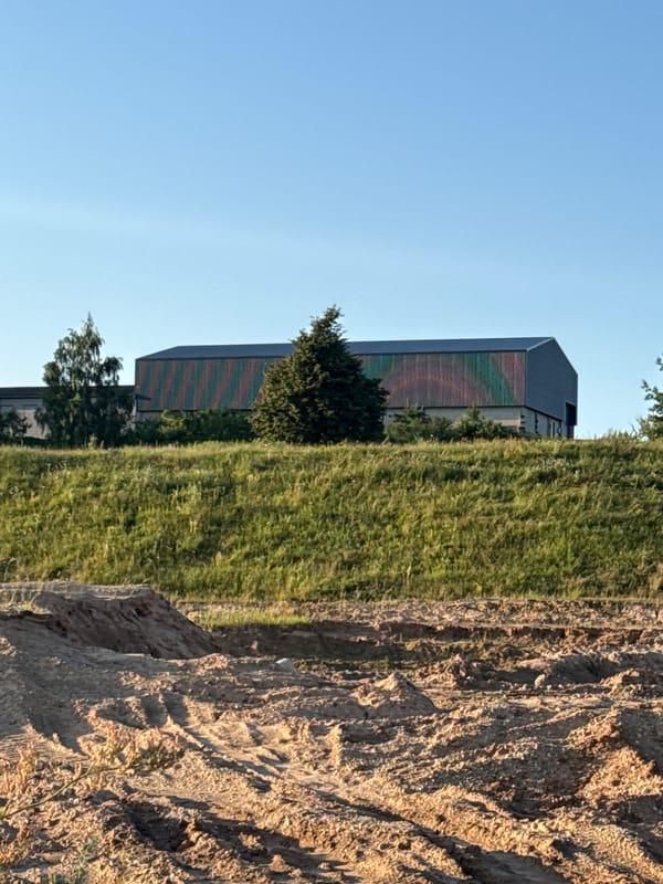 Countryside and horses near a modern building in rural Lithuania
