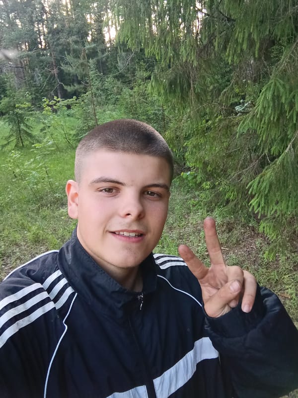 Young man takes selfie portrait in wooded setting