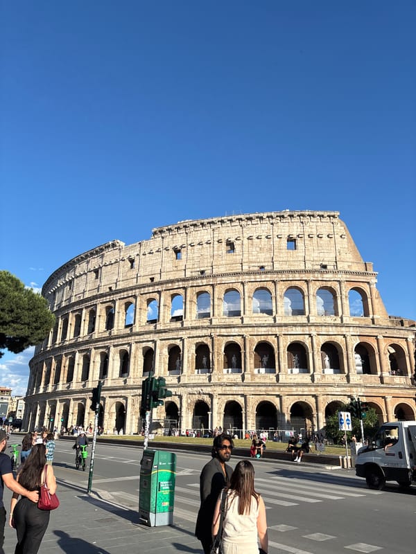 Clear skies frame Rome's Colosseum as tourists gather