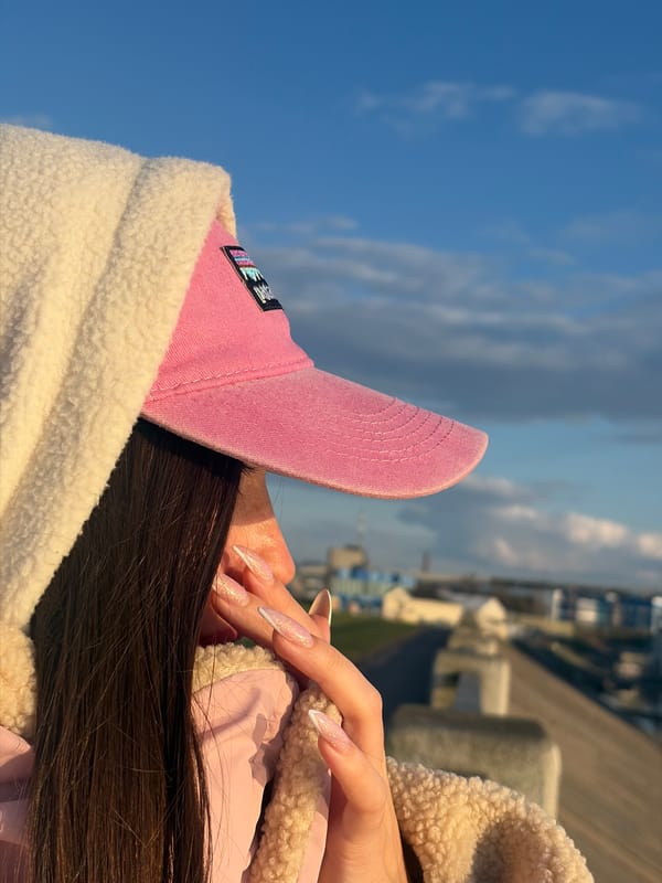Person in pink cap photographed against blue sky