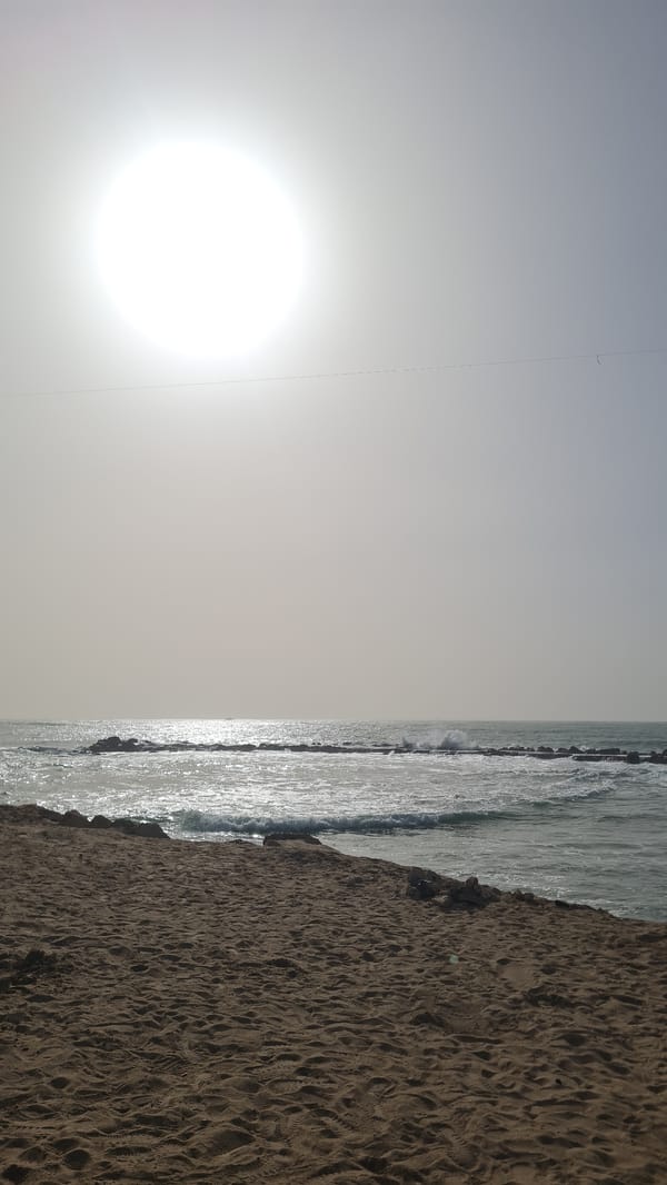 Woman documents beach visit in Nahariyya on cloudy afternoon