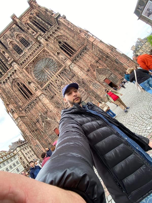 Tourist poses at Strasbourg Cathedral amid afternoon crowd