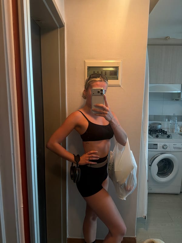 Woman with smartphone captured in apartment mirror reflection, Seoul