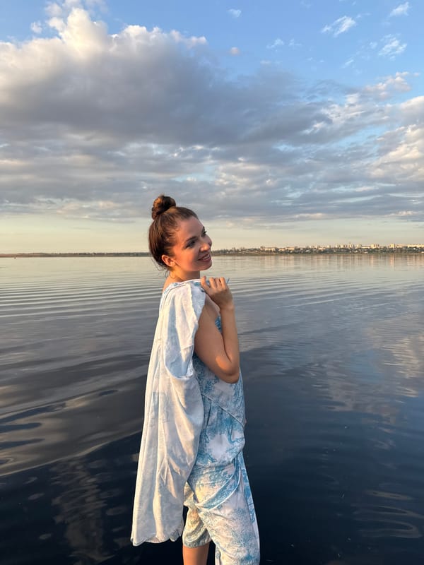 Floating in dress, Odesa waterfront, city skyline behind