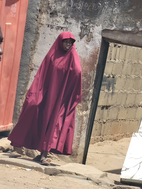 Person photographed against weathered walls in Maiburiji, Nigeria