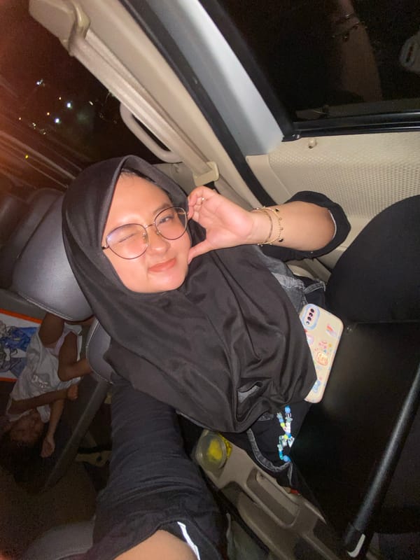 Person with hijab sits in car in Surabaya