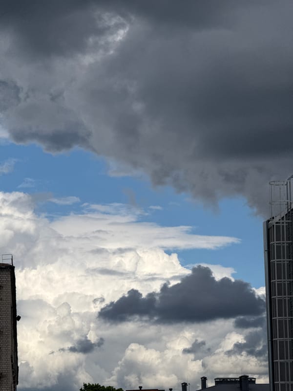 Dramatic storm clouds contrast with sunlight over Riga